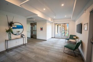 A modern hotel lobby with a console table, seating area, and a large window with a view.