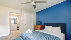 A bedroom with a bed, a blue wall, a ceiling fan, and a wooden floor. - Tangerine 2Bed 2Bath at 5 min walk to NRG near TMC (Houston)