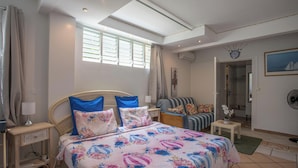 Una camera da letto con un letto, comodini, una sedia, una finestra e una porta.