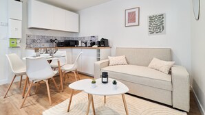 Un espacio habitable moderno con comedor, kitchenette y sofá.