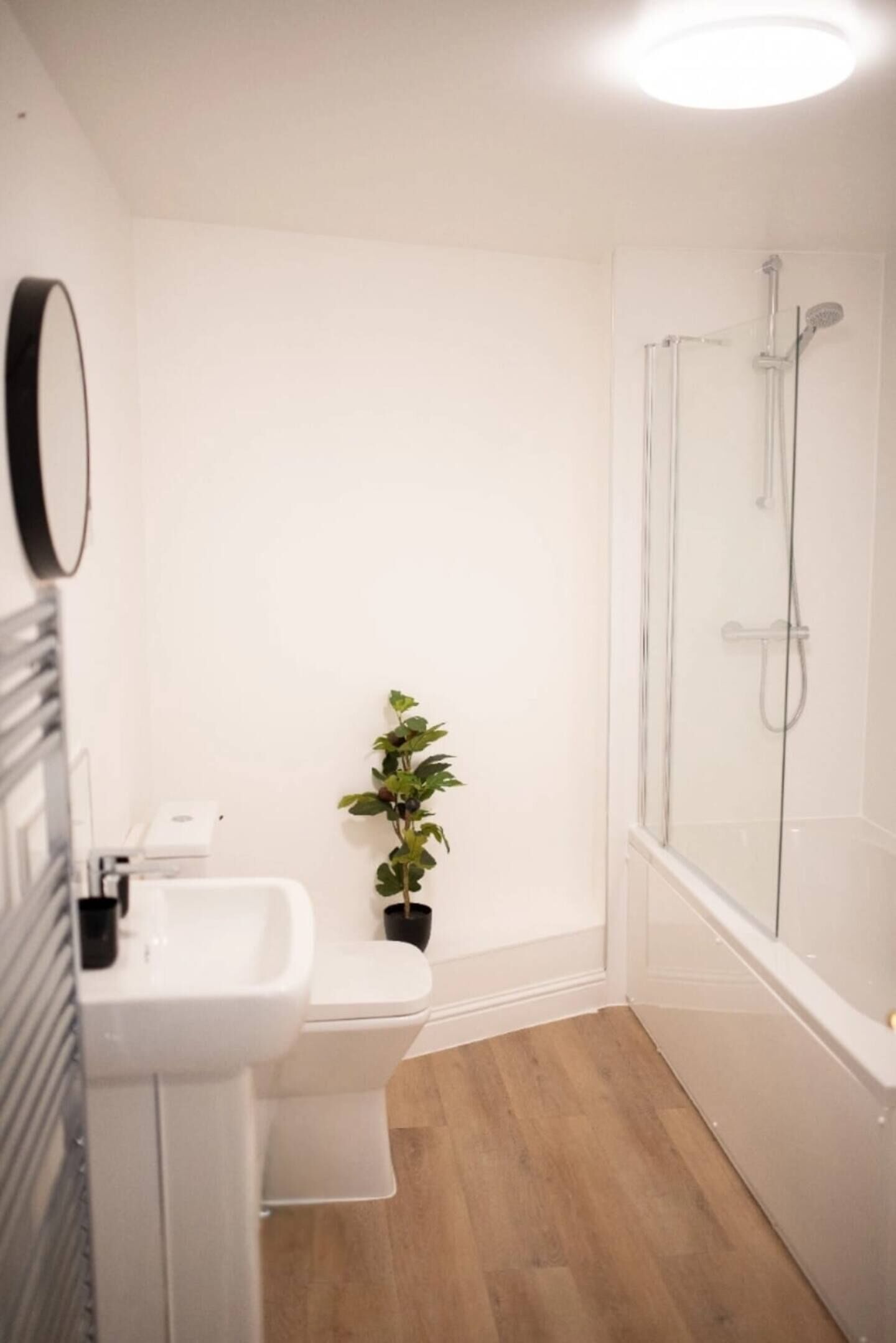Et badeværelse med toilet, vask og bruser.