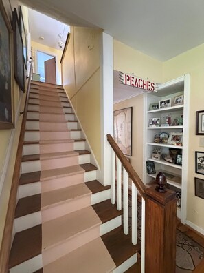 A staircase with alternating white and brown steps leading to a landing. - Cottage Close to the Lake! (Lakeside)