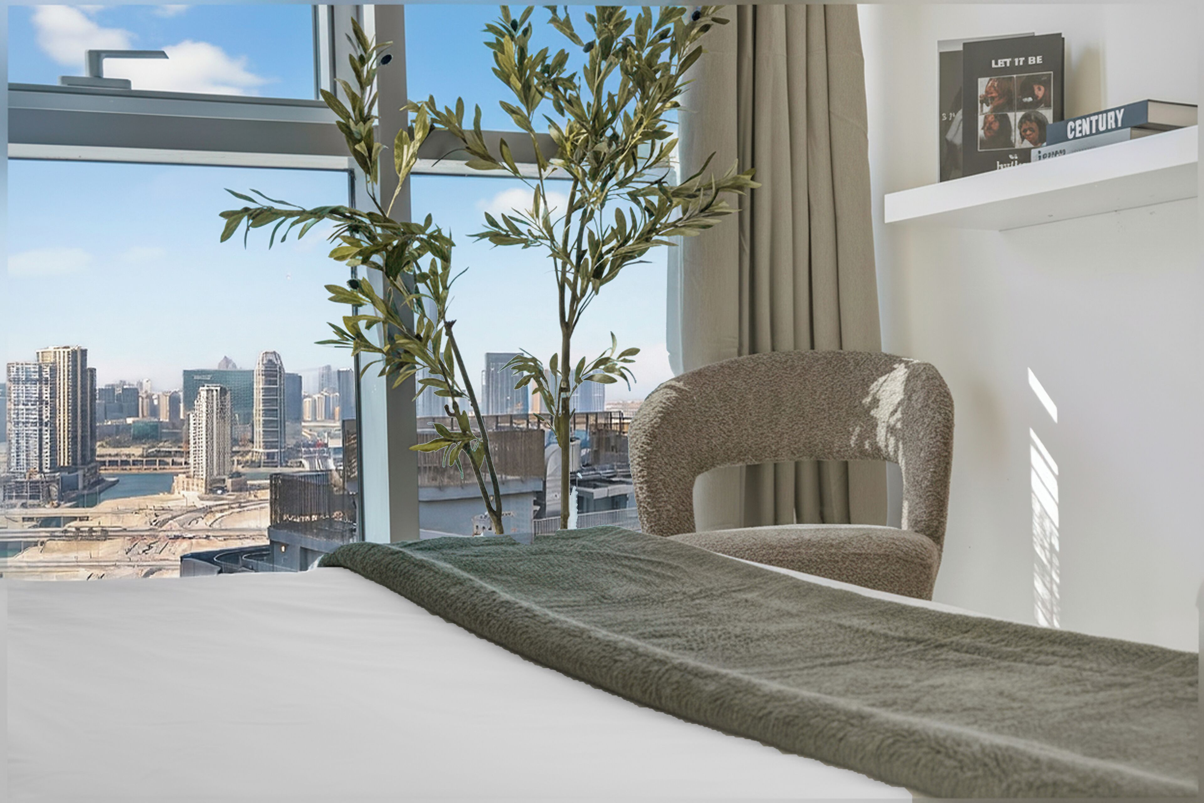 Een moderne hotelkamer met uitzicht over de stad, een comfortabele fauteuil, een net opgemaakt bed en een plankje met een boek.