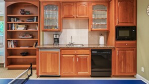 A kitchen with wooden cabinets, a dishwasher, a microwave, and a coffee maker. - The Hideaway | Pool,Tennis Court, Outdoor Kitchen (Santa Rosa)