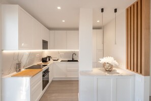 A modern kitchen with white cabinetry, a wooden countertop, and a marble backsplash. - Lux 4BR Sorrento Home with SeaView Terrace (Sorrento)