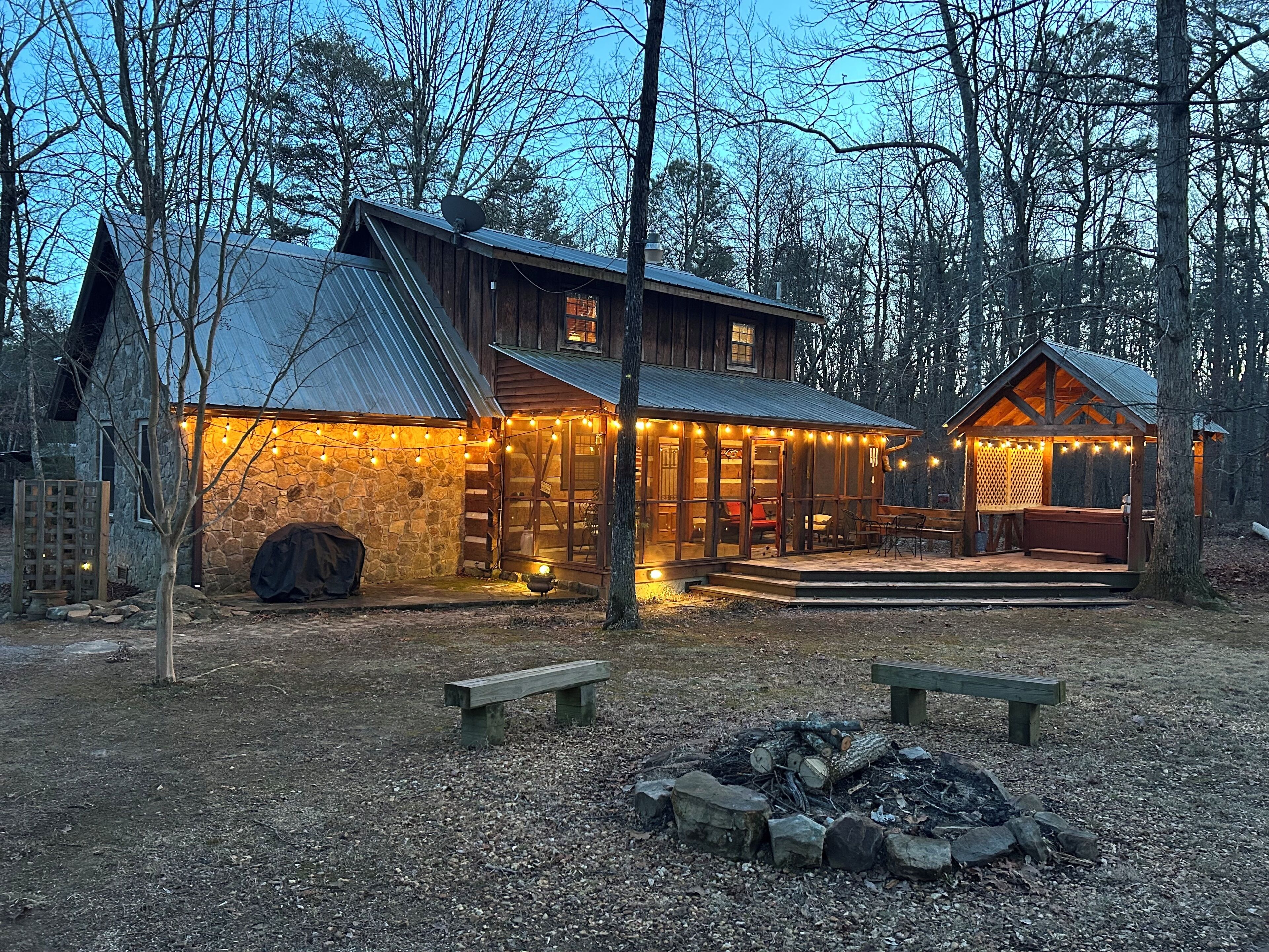 Full view of the back porch, deck, hot tub, and fire pit from the back yard
