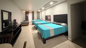 A hotel room with three beds, a desk with a computer, and a television. - Hotel Nieto Express (Matamoros)