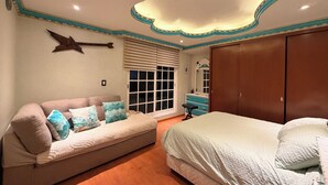 Une chambre à coucher comprenant un lit, un canapé, une commode et une armoire.