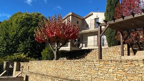 A poolside area with a stone wall, a pergola, and a building with a balcony. - Mas Tihou charming Provencal estate✨& Nordic bath 🫧 (Le Beausset)