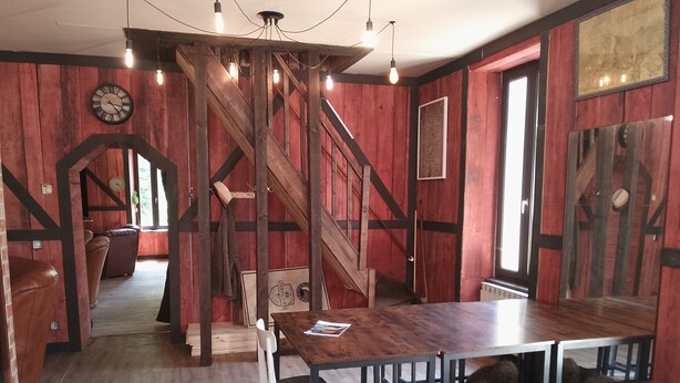 A dining area with a wooden staircase, a clock, and a 'Game of Thrones' themed wall. - GITE DE GROUPES 210m2, sleeps 15, pets welcome! (Cransac)