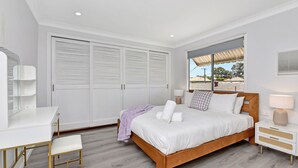 A bedroom with a bed, bedside tables, a desk, and a chair. - Cessnock Country Gateway to Vineyards View (Cessnock)