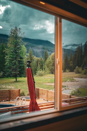 A room with a large window overlooking a mountainous landscape.