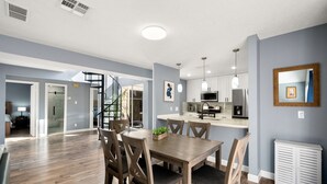 A modern kitchen with white cabinets, stainless steel appliances, and pendant lighting. - Houston Energy Corridor Home (Houston)
