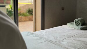 A bedroom with a large window, a bed with white bedding, and a green towel on the bed. - 2CH/2SDB - Modern & Bright - Wi-Fi - Garage - Streetcar 2 min (Casablanca)