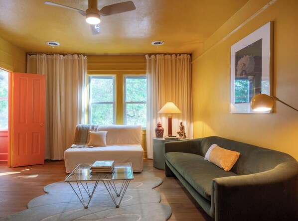 A living room with a sofa, a coffee table, a lamp, and a painting on the wall.
