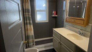 A bathroom with a toilet, sink, and shower. - 2-bedroom house in Springfield (Springfield)