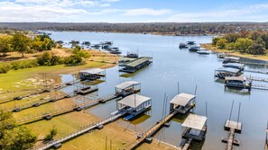 A marina with multiple docks and boats, surrounded by greenery and a distant tree line. - Bixby Cove Cabin #3 (Porum)