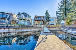 A waterfront property with a wooden dock, a swimming pool, and modern multi-story buildings with balconies. - Tahoe Keys Getaway | Waterfront w/ Views from Deck (South Lake Tahoe)