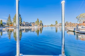 Ein Yachthafen mit ruhigem Wasser, anglegerten Booten und Wohnhäusern im Hintergrund.