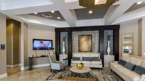 Una sala de estar moderna con un sofá, sillones, una mesa de centro y un televisor.