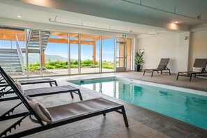 A swimming pool with lounge chairs, a staircase, and a view of greenery. - 210 | Chic Escape | View & Comfort with Pool (Baie-Saint-Paul)