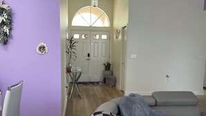 Een woonkamer met een grijze bank, een geruit plaid en een kleine tafel.