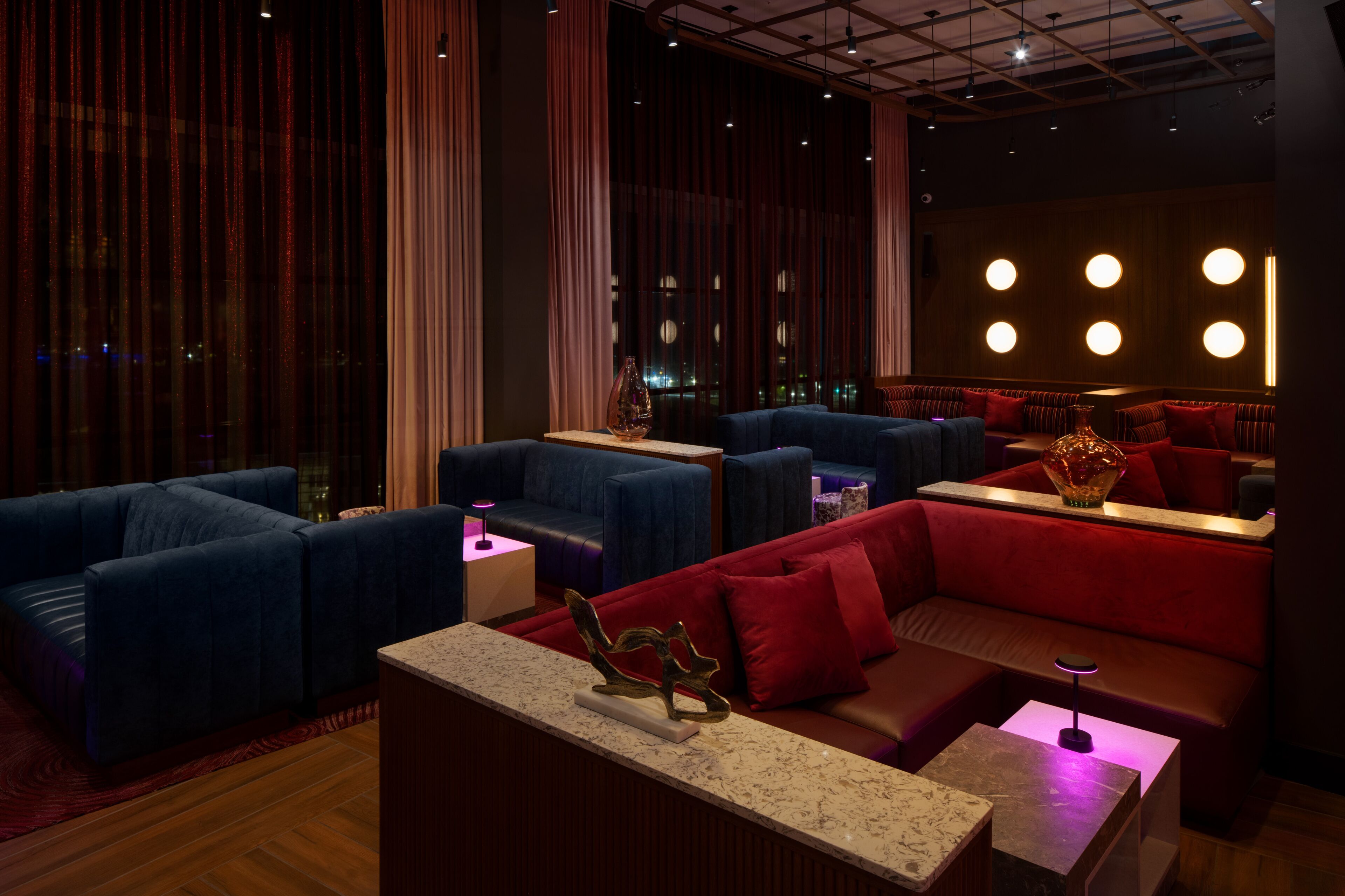 Una moderna area lounge con posti a sedere, una reception in marmo e illuminazione d'atmosfera.