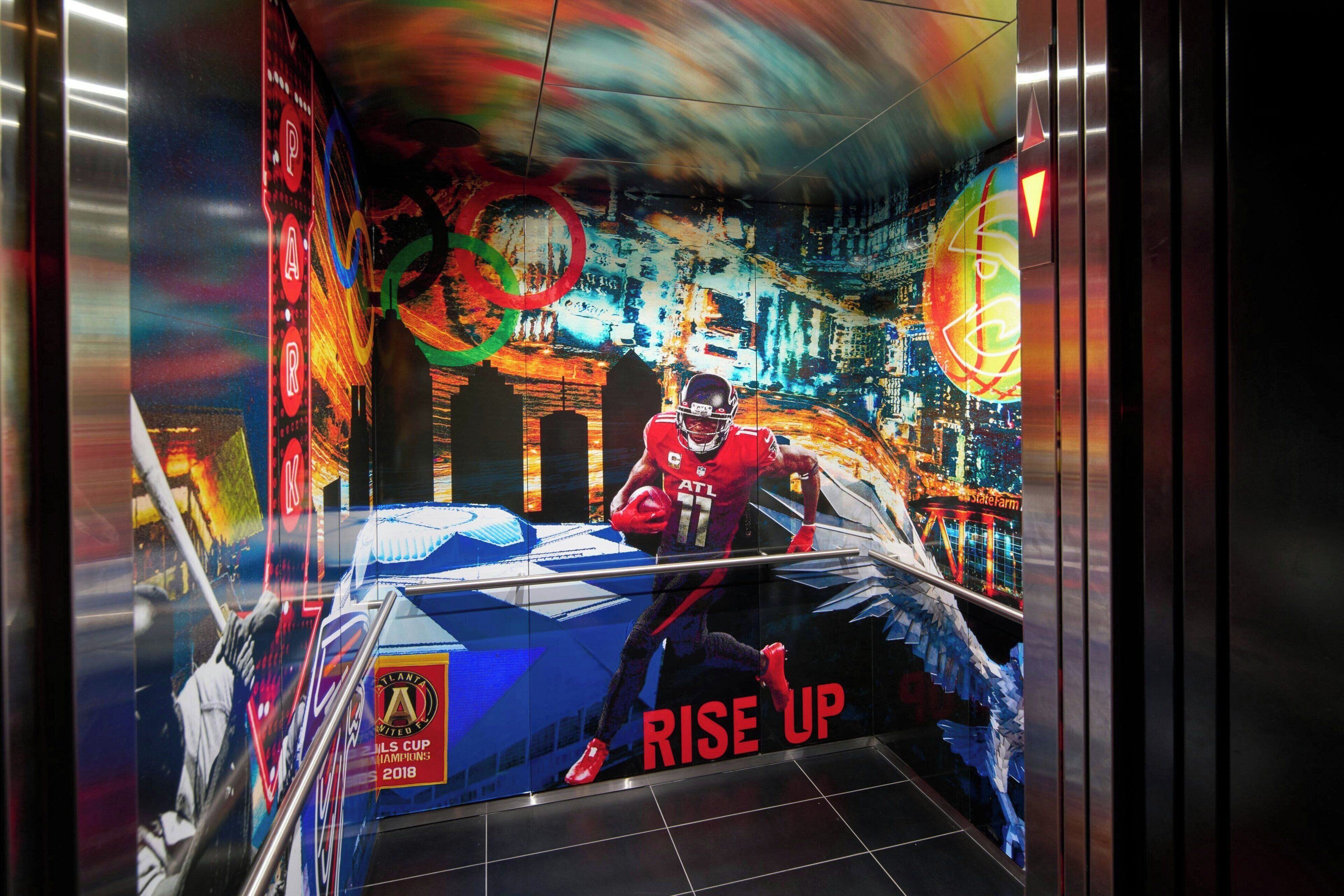 A sports-themed mural with a football player, the text 'RISE UP,' and the Atlanta Falcons logo.