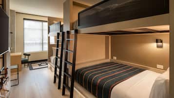 A bunk bed room with a desk, chair, and a window.