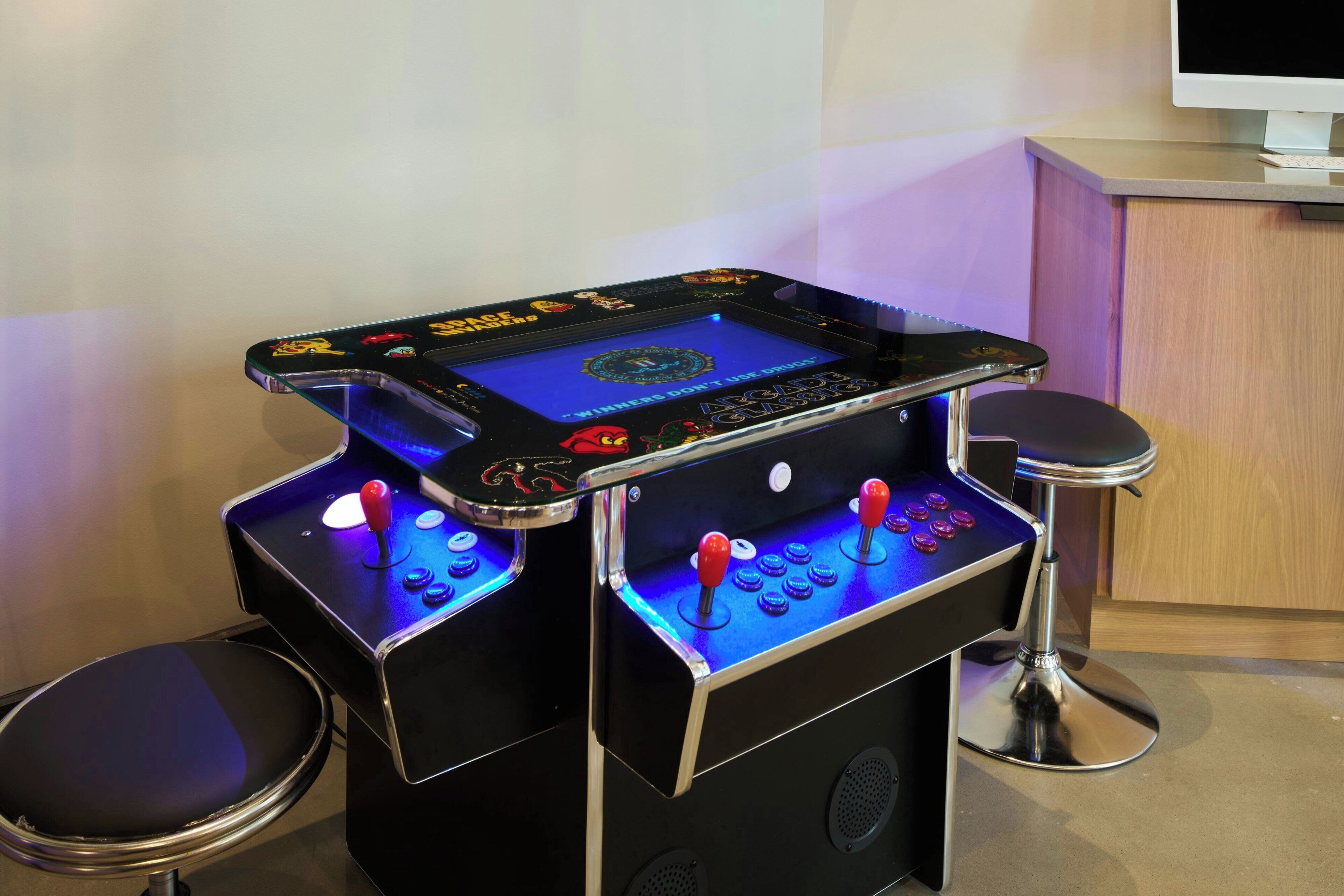Una mesa de juegos con dos sillas, un monitor y un teclado.