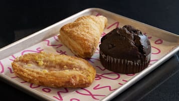 A tray with three pastries on a table.
