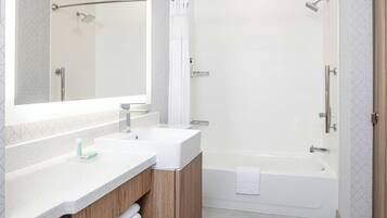 A modern bathroom with two sinks, a shower, and a bathtub.