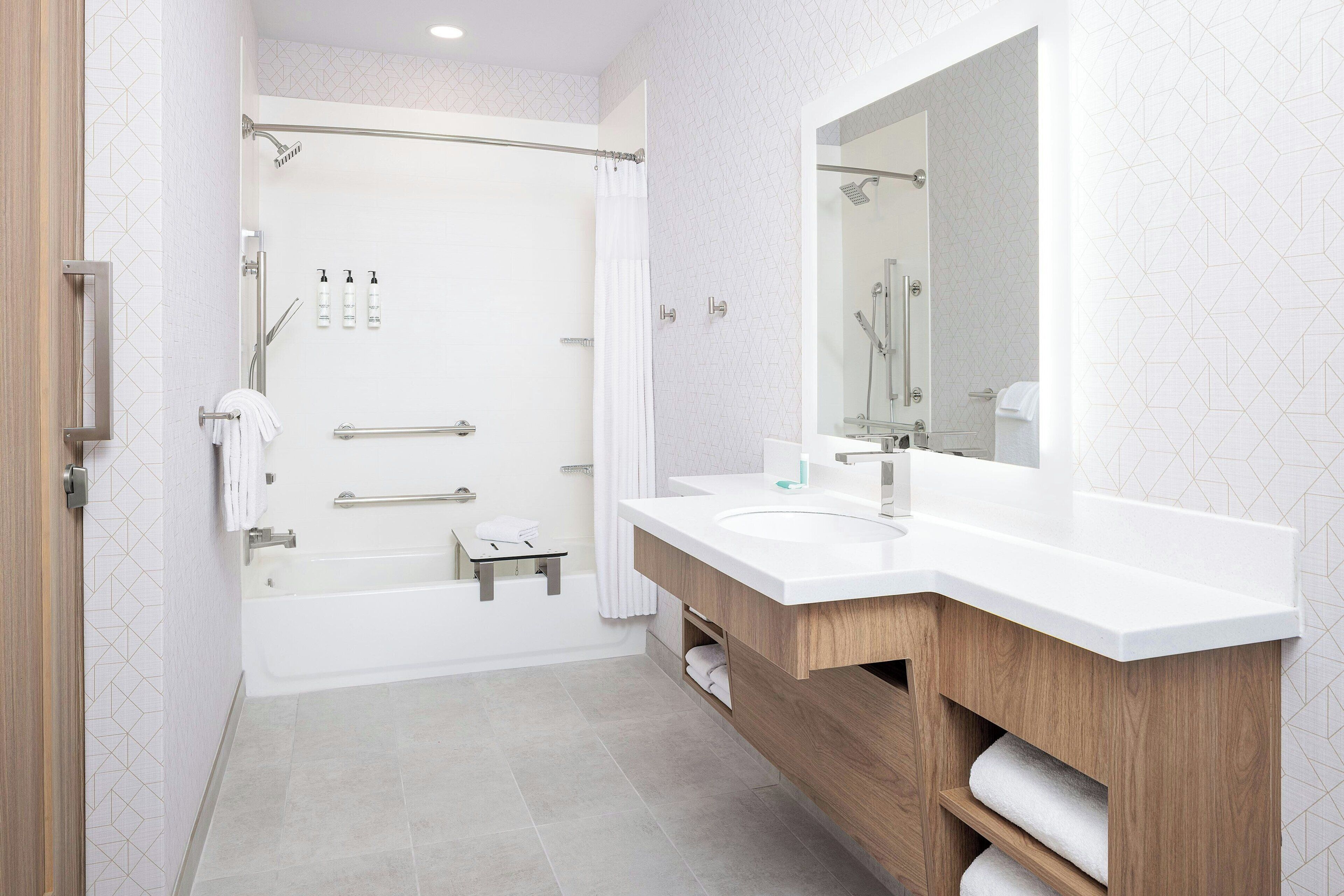 A modern bathroom with a shower, two sinks, a large mirror, and wooden vanity.