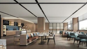 Un restaurant moderne doté d’une grande salle à manger à tables conviviales, d’un bar et d’un espace détente avec des tables et des chaises.