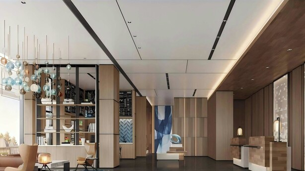 Un hall d’hôtel moderne avec un espace salon central, une bibliothèque et un comptoir d’accueil.