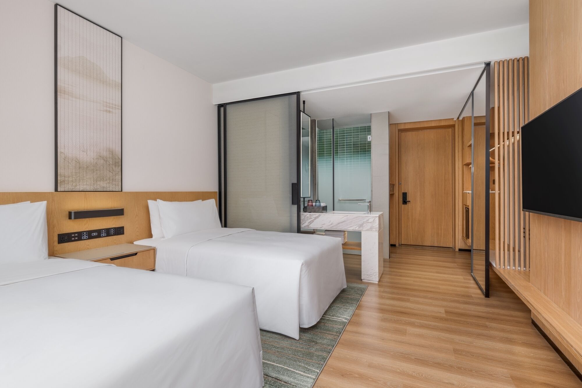 Une chambre d’hôtel avec deux lits, un grand miroir, une armoire en bois et un téléviseur.