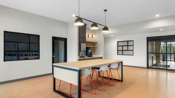 A modern kitchen with a central island, pendant lighting, and a view to the dining area.