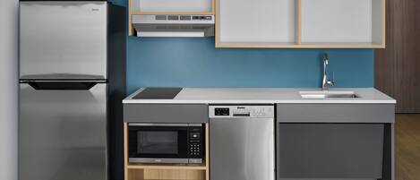 Una cocina moderna con refrigerador, microondas y lavavajillas incorporados.
