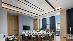 Un espace repas moderne avec une table ronde, des chaises et une vue sur la ville.