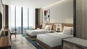 Une chambre d’hôtel moderne avec deux lits, un bureau, une chaise et une grande fenêtre donnant sur la ville.