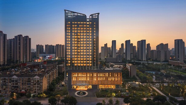 Un hôtel de grande hauteur au design moderne, doté d’une entrée imposante et de nombreux étages.