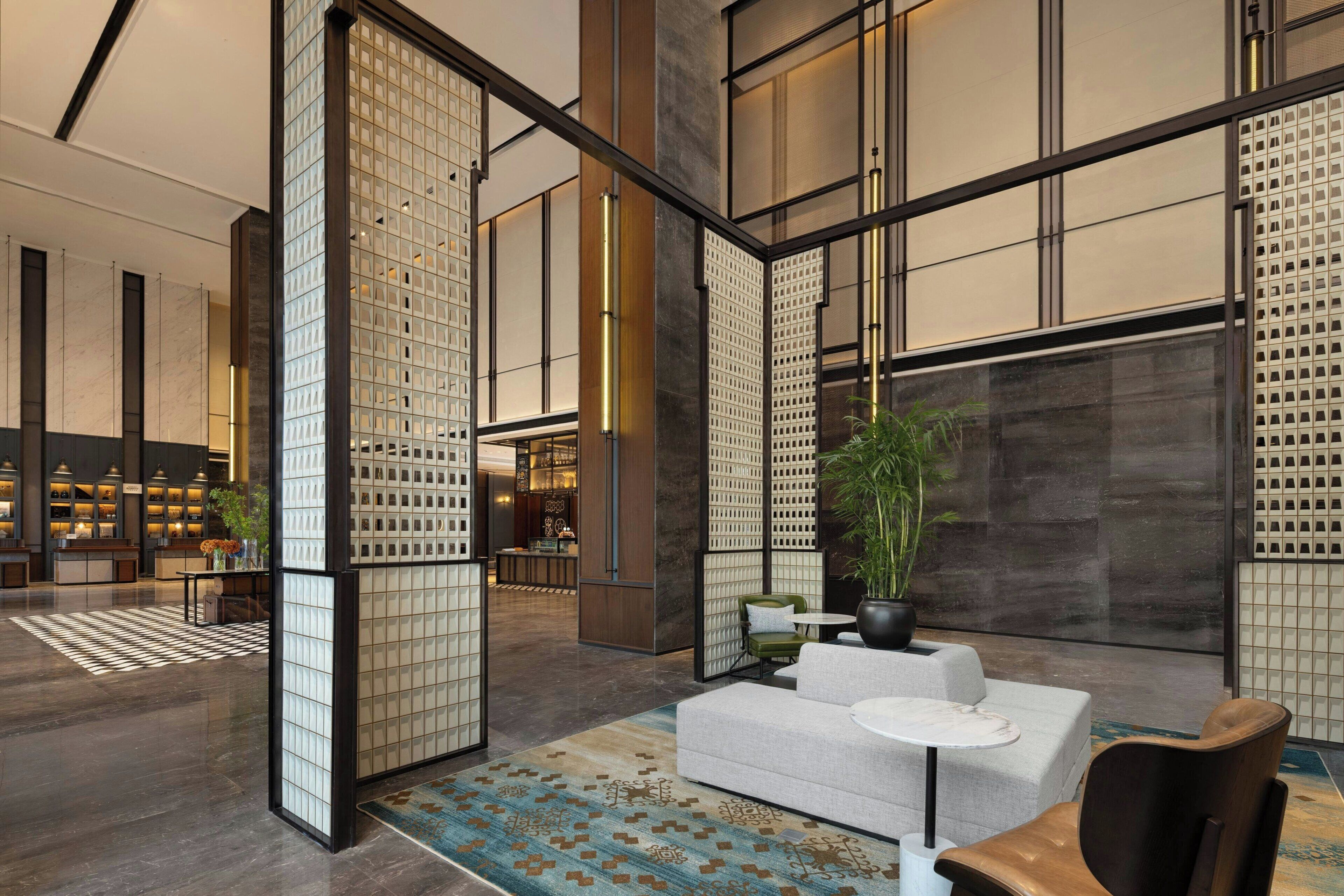 A modern lobby with a seating area, a reception desk, and a view of the interior.
