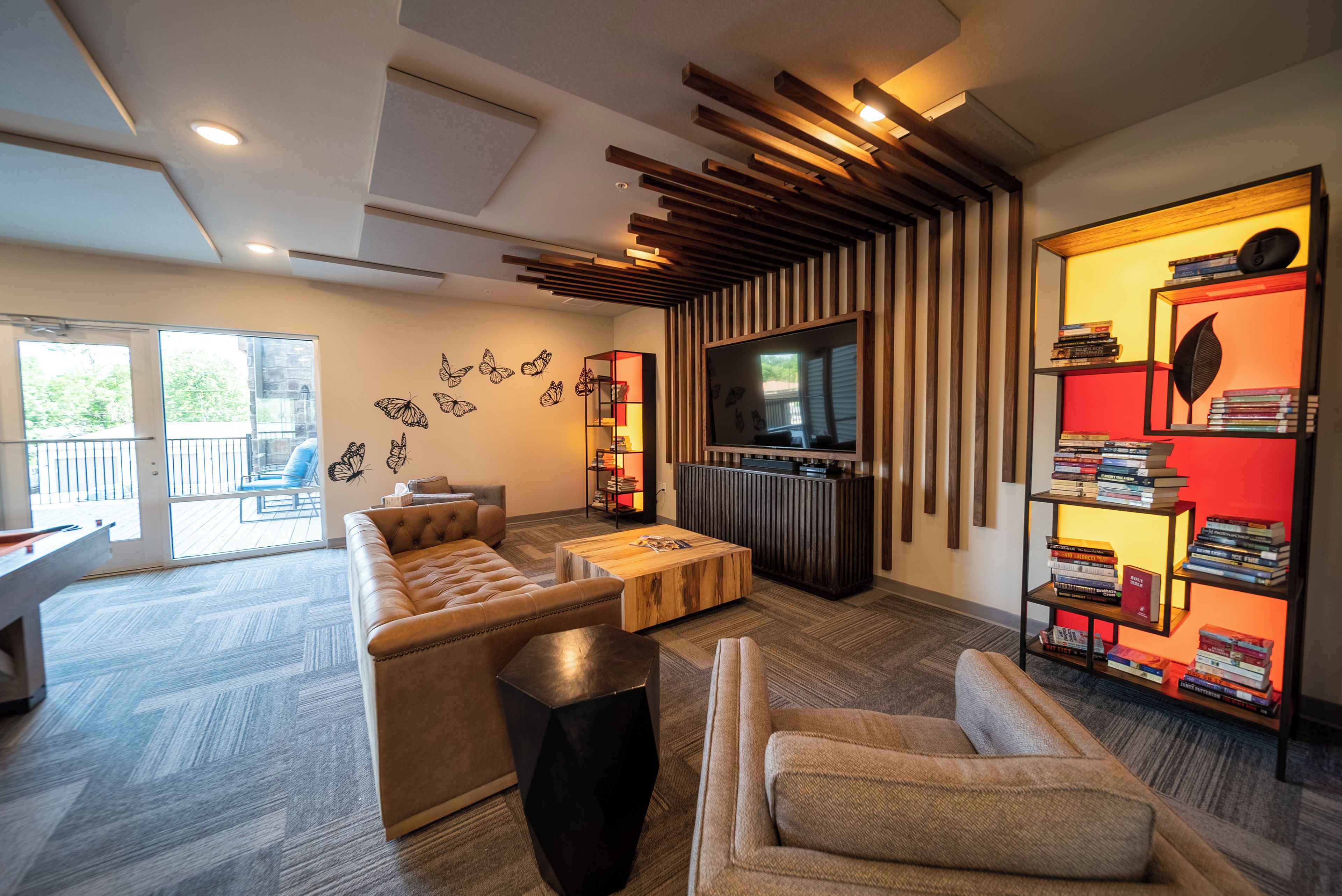 Una sala de estar moderna con un sofá modular, una mesa de centro, una estantería y un televisor.