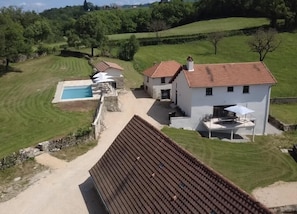 A residential property with a swimming pool, a patio with outdoor furniture, and a well-maintained lawn. - Gîtes de France® - Domaine de Phebus (SAINT MEDARD DE PRESQUE)