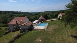 A residential property with a swimming pool, a stone wall, and a view of the countryside. - Gîtes de France® - Domaine de Phebus (SAINT MEDARD DE PRESQUE)