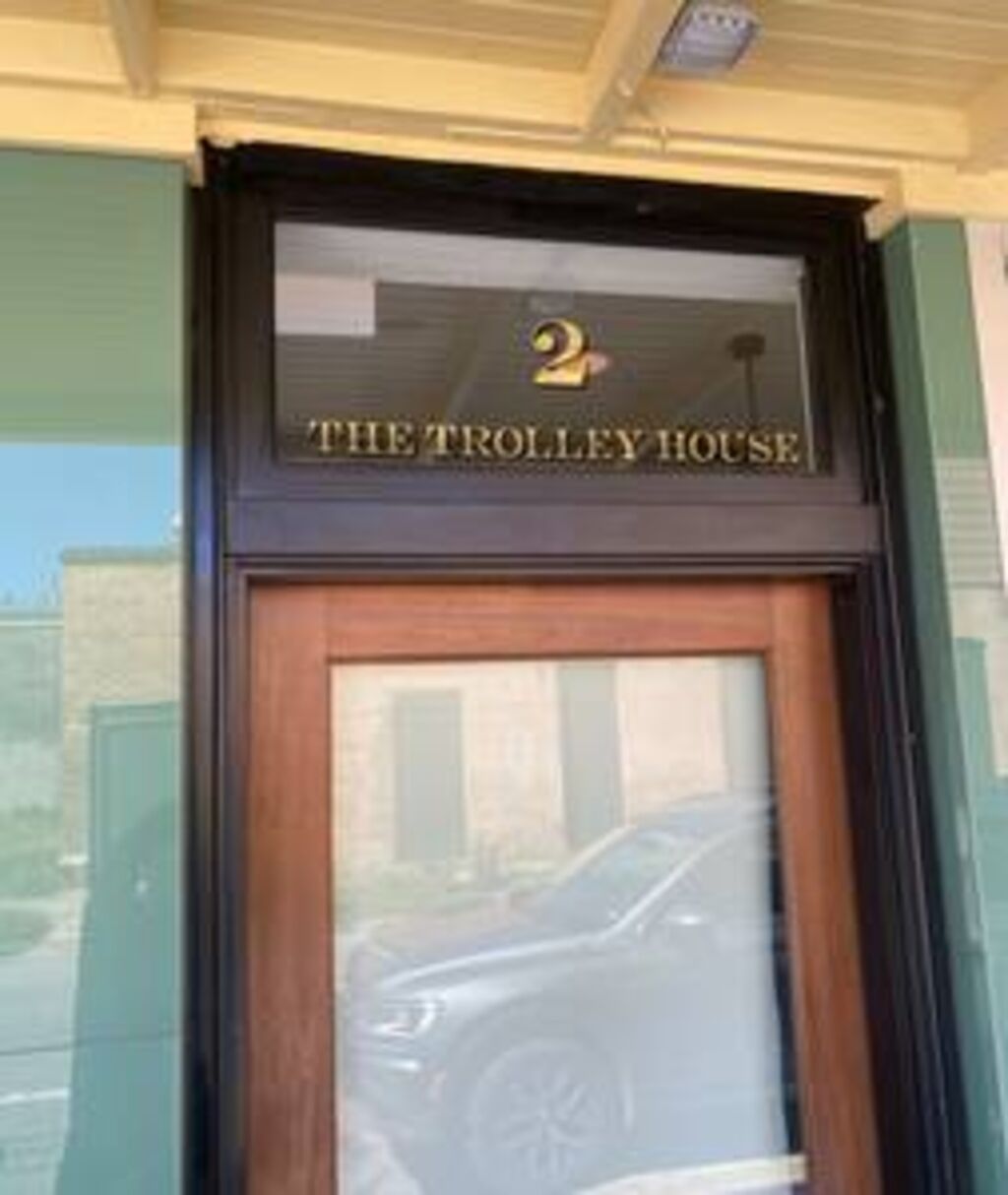 Entrada de un edificio con un cartel que dice 'THE TROLLEY HOUSE' y el número '2' encima.