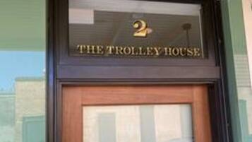 Entrada de un edificio con un cartel que dice 'THE TROLLEY HOUSE' y el número '2' encima.