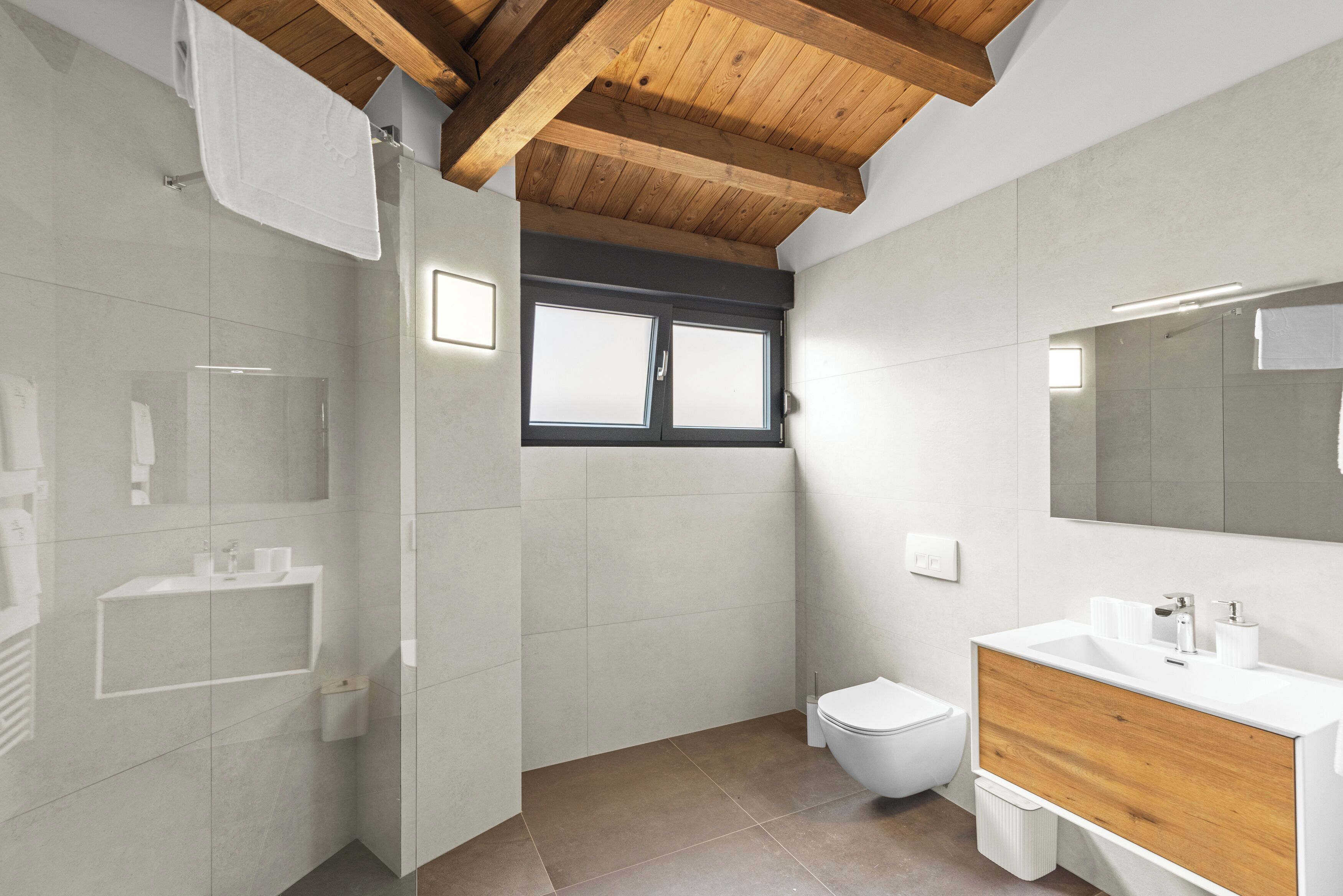 Une salle de bain moderne équipée d’une douche, de toilettes et d’un meuble-lavabo.