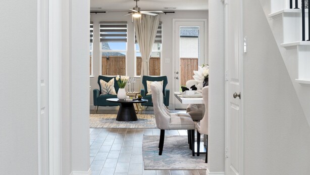 A modern dining area with a round table, two chairs, and a ceiling fan. - Where Family Adventures Begin (Seagoville)