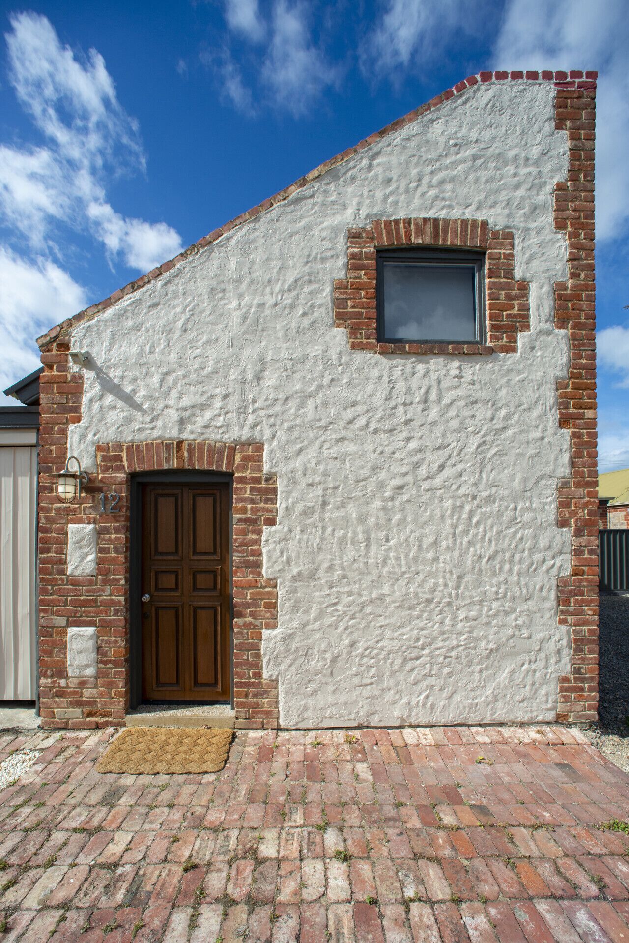 A building with a brick facade, a wooden door, and a small window.